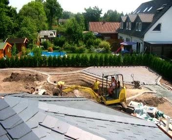 Von oben fotografierte Gartenbaustelle: Ein kleiner gelber Bagger hebt eine Grube für einen Pool aus, während Mitarbeiter die Flächen vorbereiten.